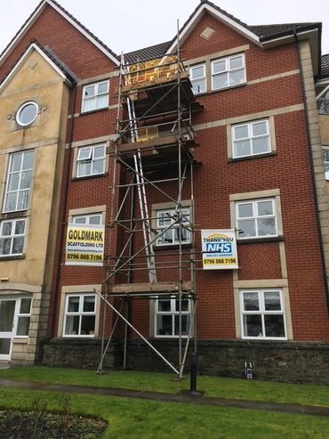 Scaffolding erected on a brick apartment building with NHS thank you sign.