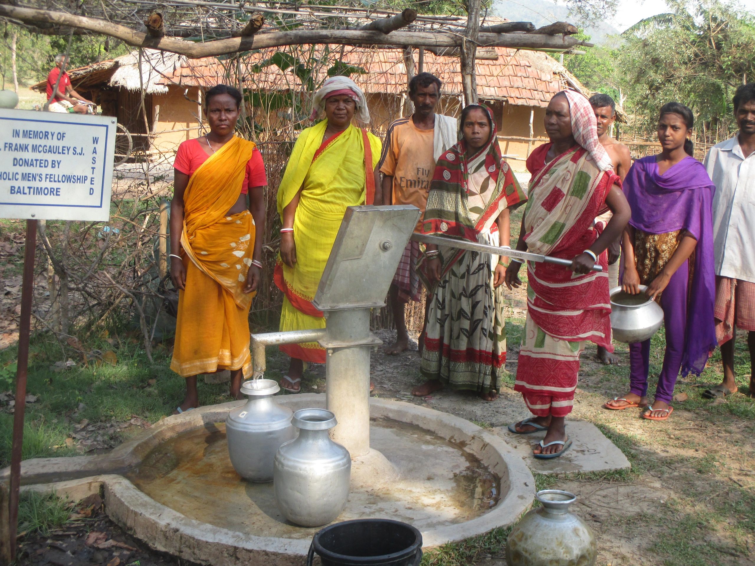 MR. SINGRAI MURMU (center)  and MRS. CHAMI SOREN  (drawing water) and Fellow  Villagers