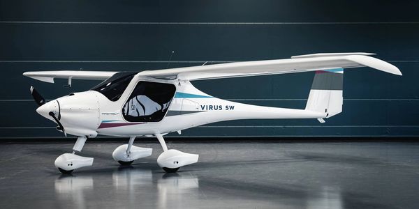 White Virus SW light aircraft on display indoors.