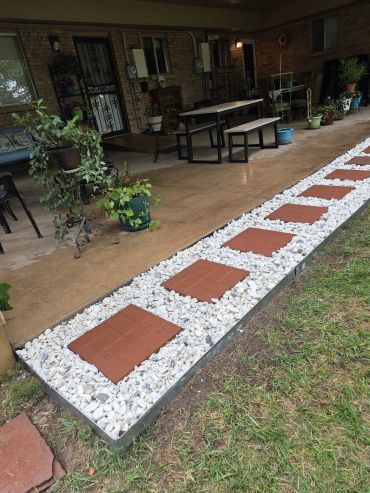 Outdoor patio with red stepping stones and white gravel.
