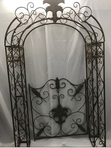 Decorative wrought iron garden arbor with intricate scrollwork.