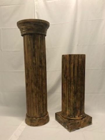 Two antique-style brown pillars of different heights.