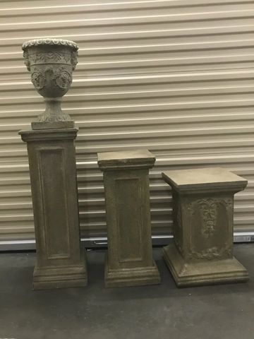 Three decorative stone pedestals of different heights.