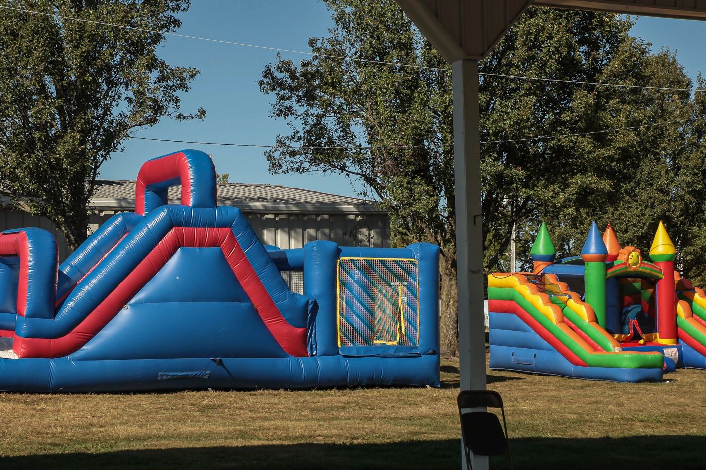 Colorful inflatable bounce houses set up outdoors on a sunny day.
