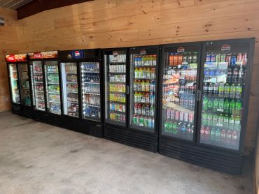 A lineup of refrigerated beverage coolers filled with various drinks.