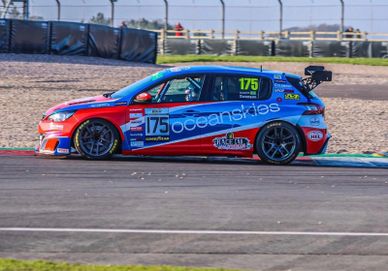 A blue and red race car with number 175 on a racetrack.