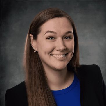 Professional headshot of a smiling woman in business attire.