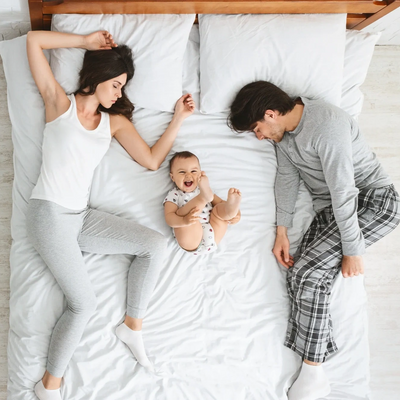 family sleeping on bed