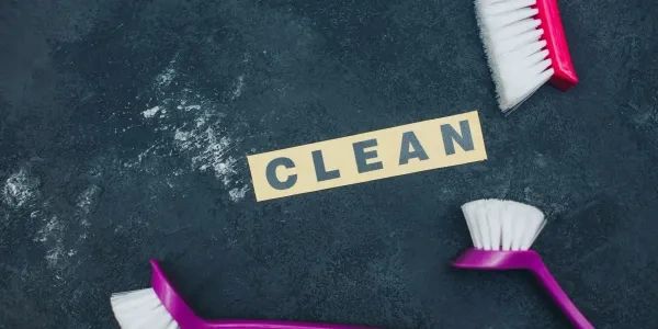Brushes surrounding the word CLEAN on a dark surface.