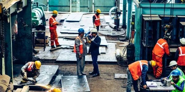 Workers in safety gear at an industrial site.