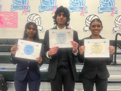Three students proudly display their certificates.