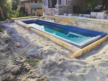 Inground pool installation in backyard.