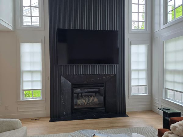 Modern living room with a black fireplace and mounted TV.