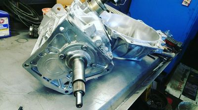 A metal automotive transmission part on a workbench in a garage. Van Nuys transmission specialists automatic