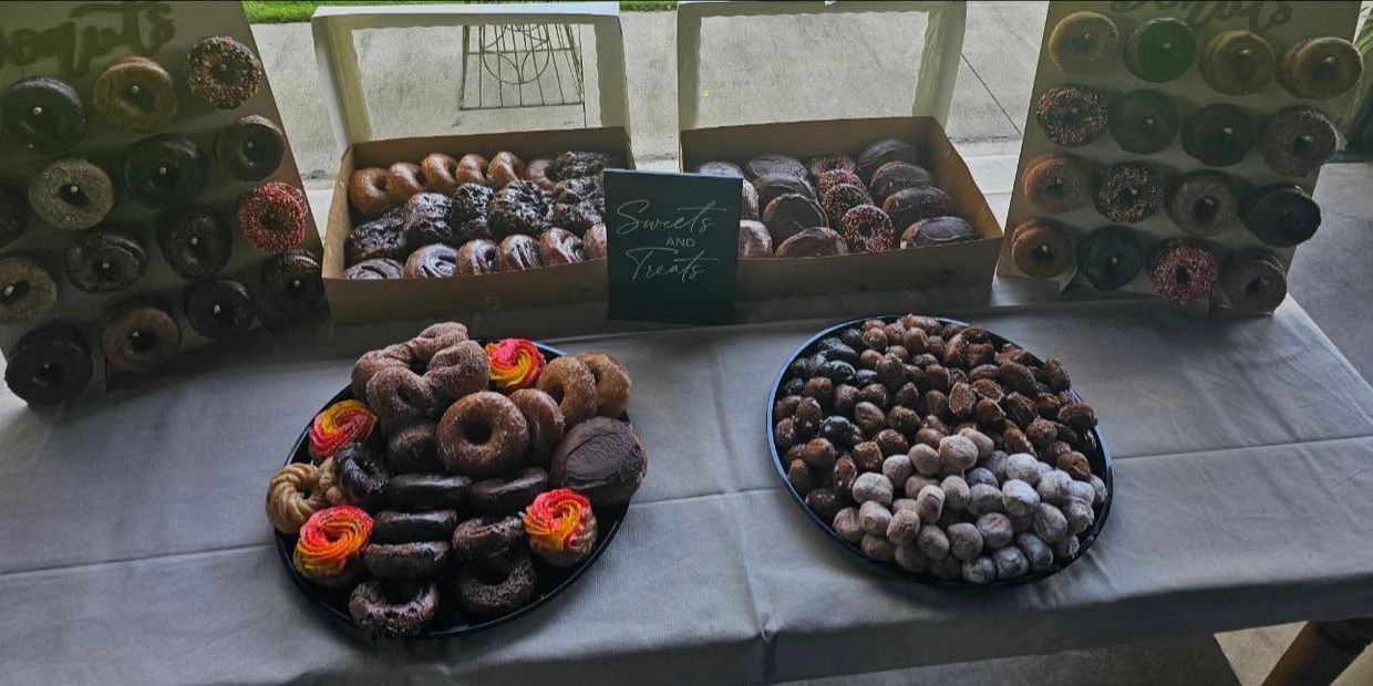 Table full of assorted donuts and sweet treats.