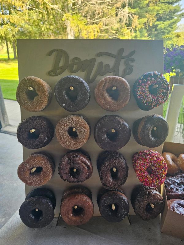 Assorted donuts displayed on a wooden board.