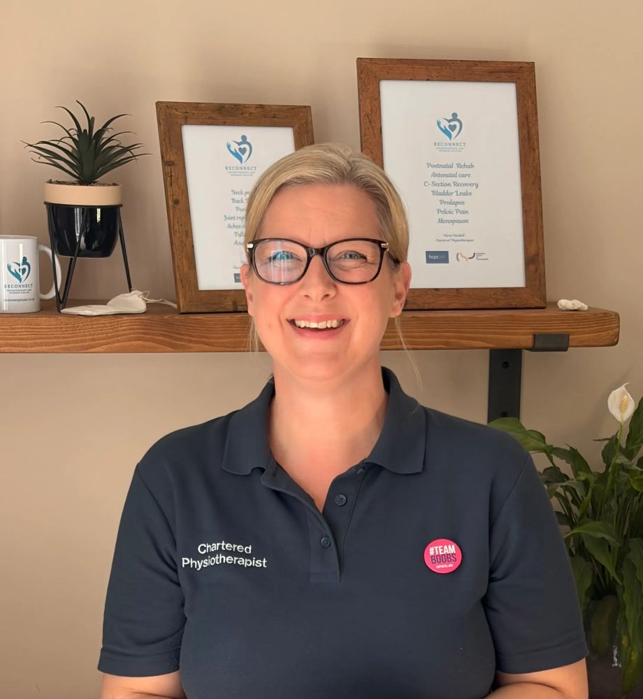 Smiling physiotherapist wearing glasses and a #TEAM BOOBS badge.