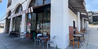Outdoor seating at a cafe along a sidewalk.