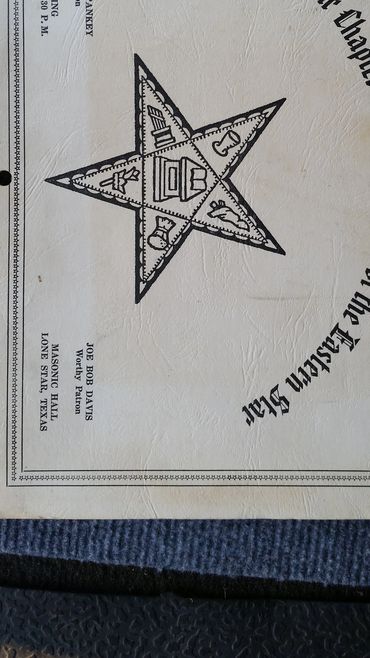 Certificate with a star emblem and text on a textured surface.