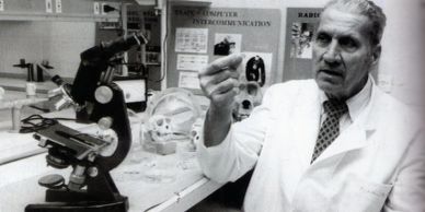 Scientist examining a slide in a lab with microscope.
