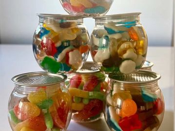 Glass jars filled with colorful gummy candies stacked in a pyramid.