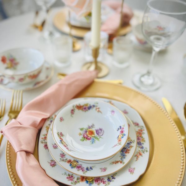 tea cups, charger plates rentals, ivory linen, blush napkins, gold silverware, taper candle rentals,