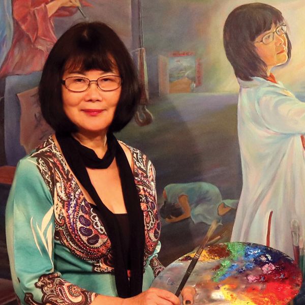 A woman painter holding a colorful palette.
