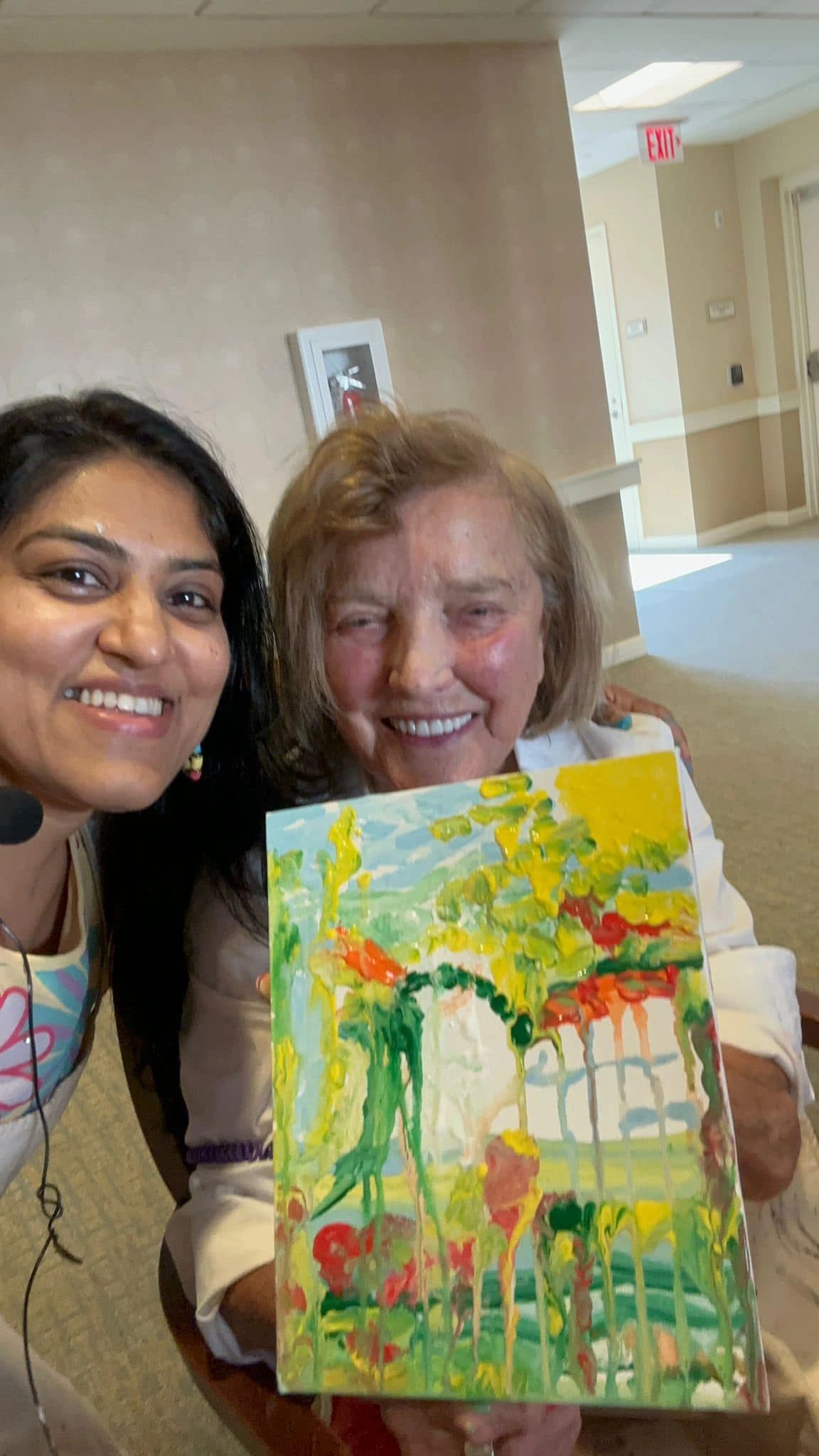 Workshop participant holding artwork next to teacher.