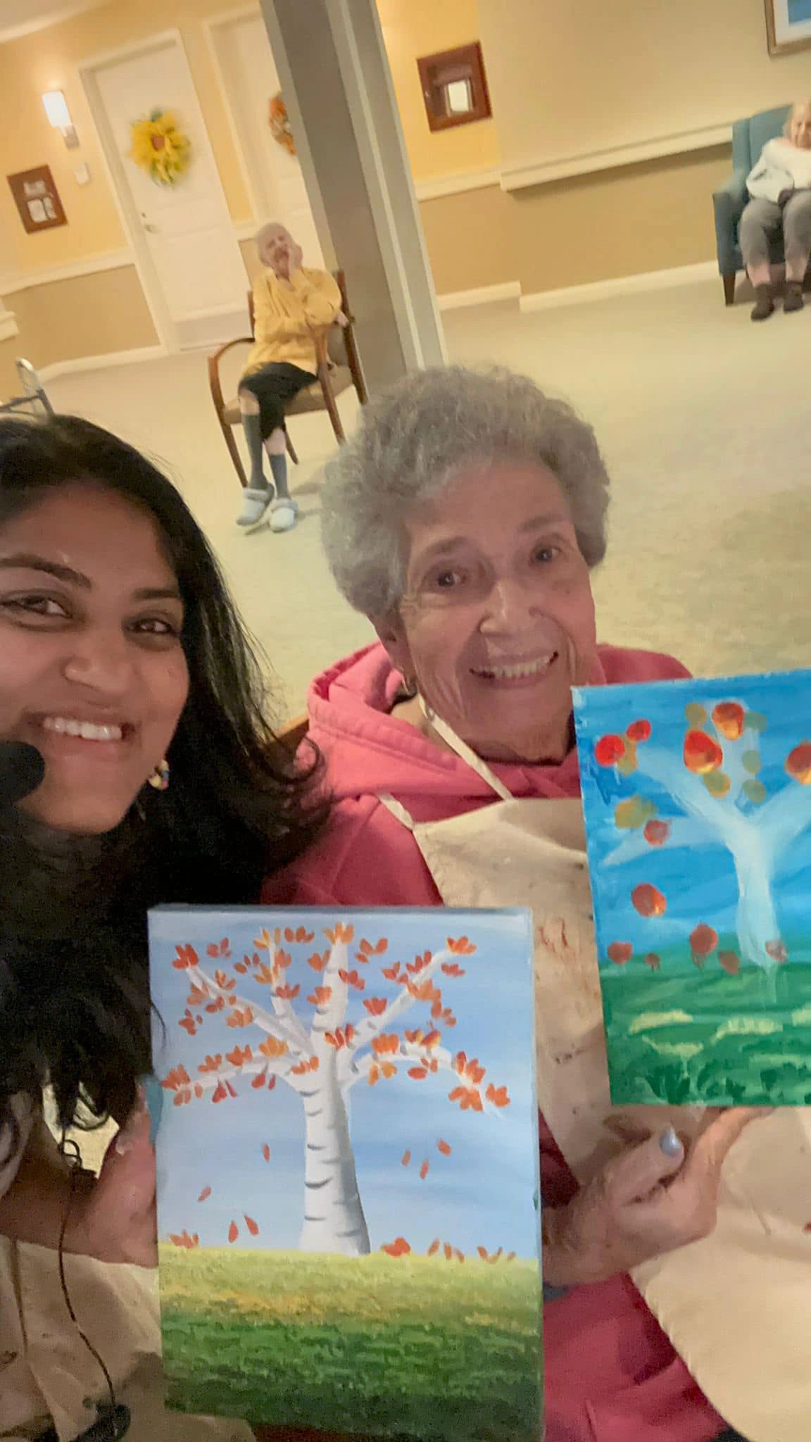 Workshop participant holding artwork next to teacher.