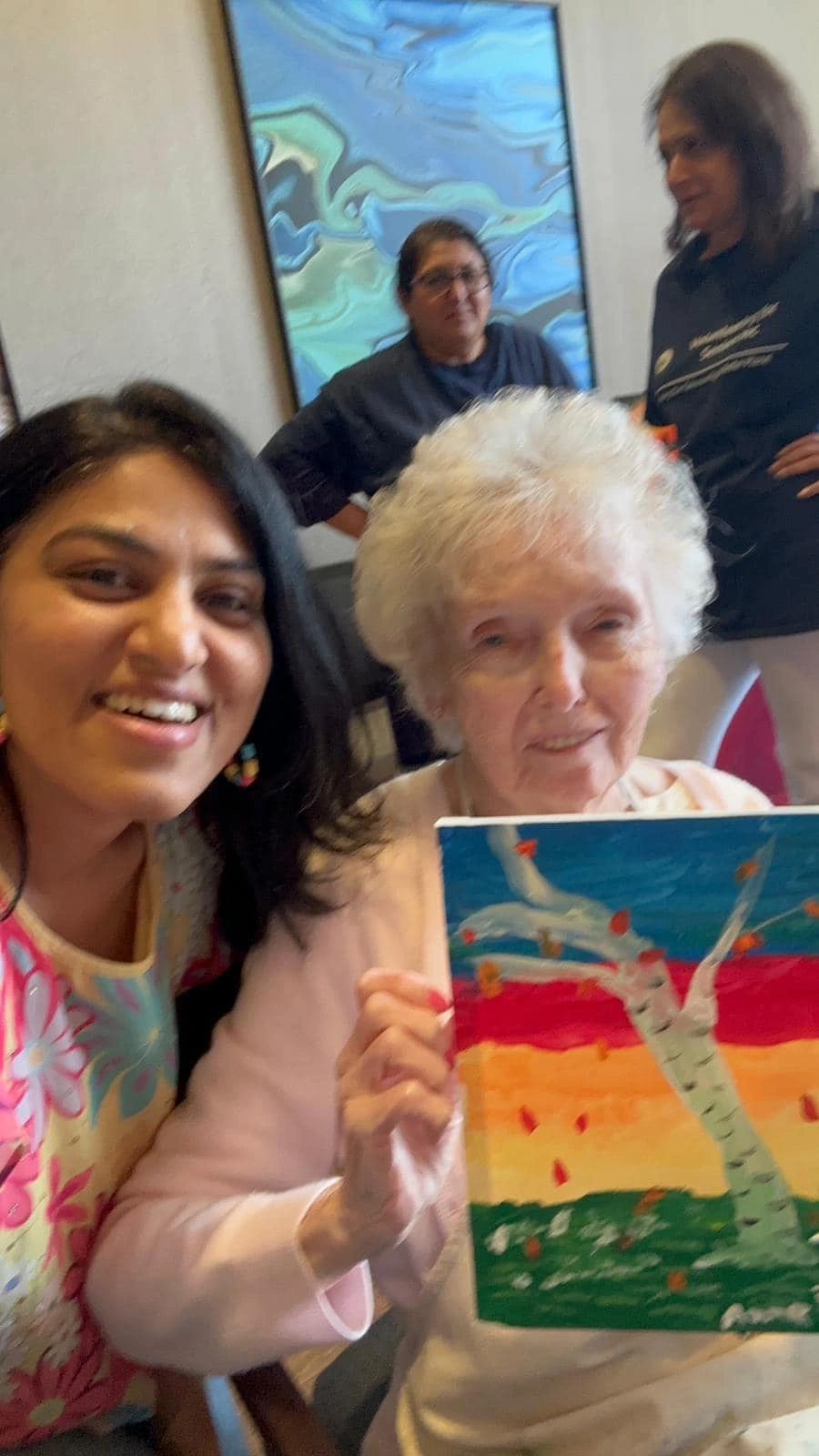Workshop participant holding artwork next to teacher.