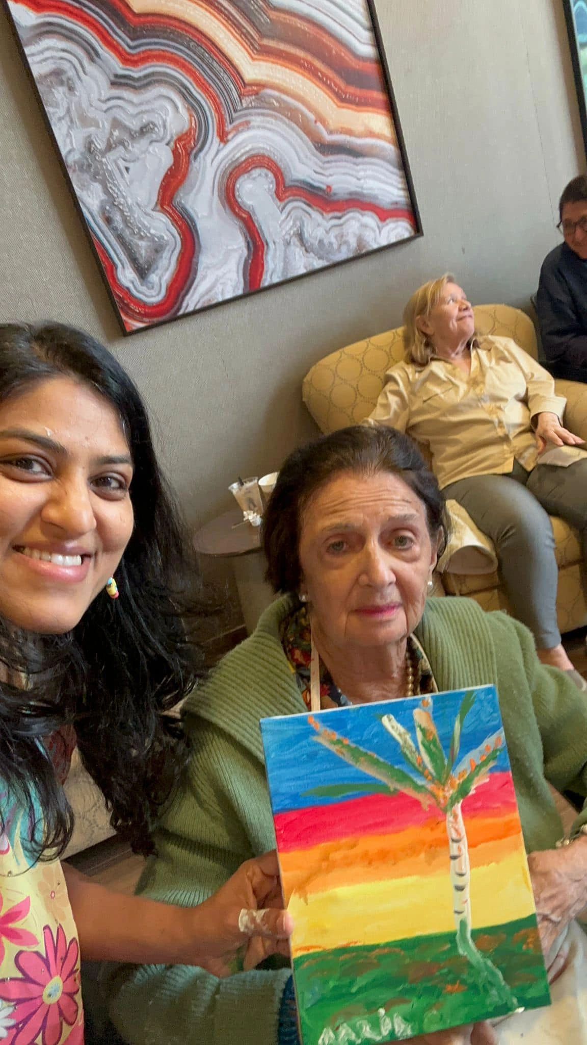 Workshop participant holding artwork next to teacher.