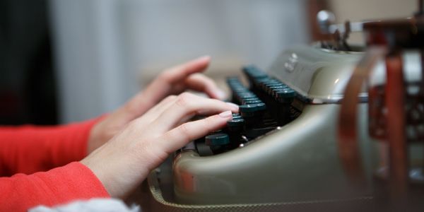 Woman typing on antique typewriter