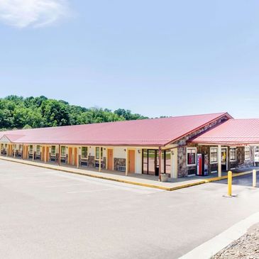 Exterior of a single-story motel with a red roof.