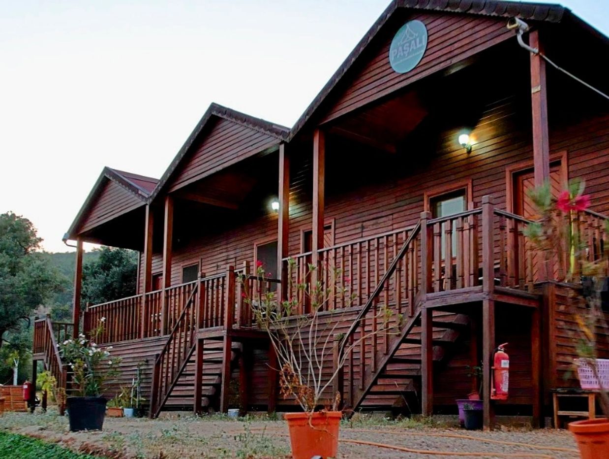 Ahşap yapıda konaklama evi ve bahçe bitkileri.