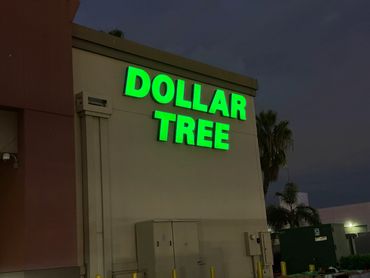 Illuminated Dollar Tree store sign at night.