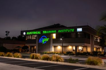Night view of the Electrical Training Institute building with illuminated signage.