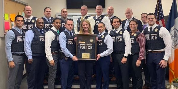 Police officers holding a framed vest photo