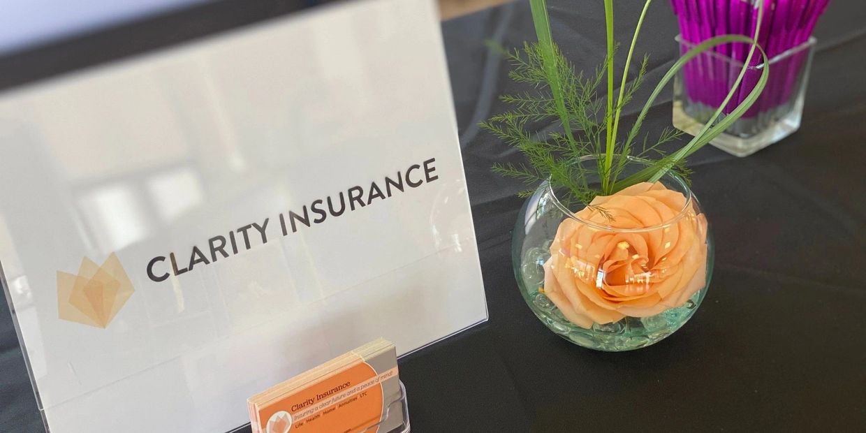 Clarity Insurance display with a flower centerpiece on a black table.