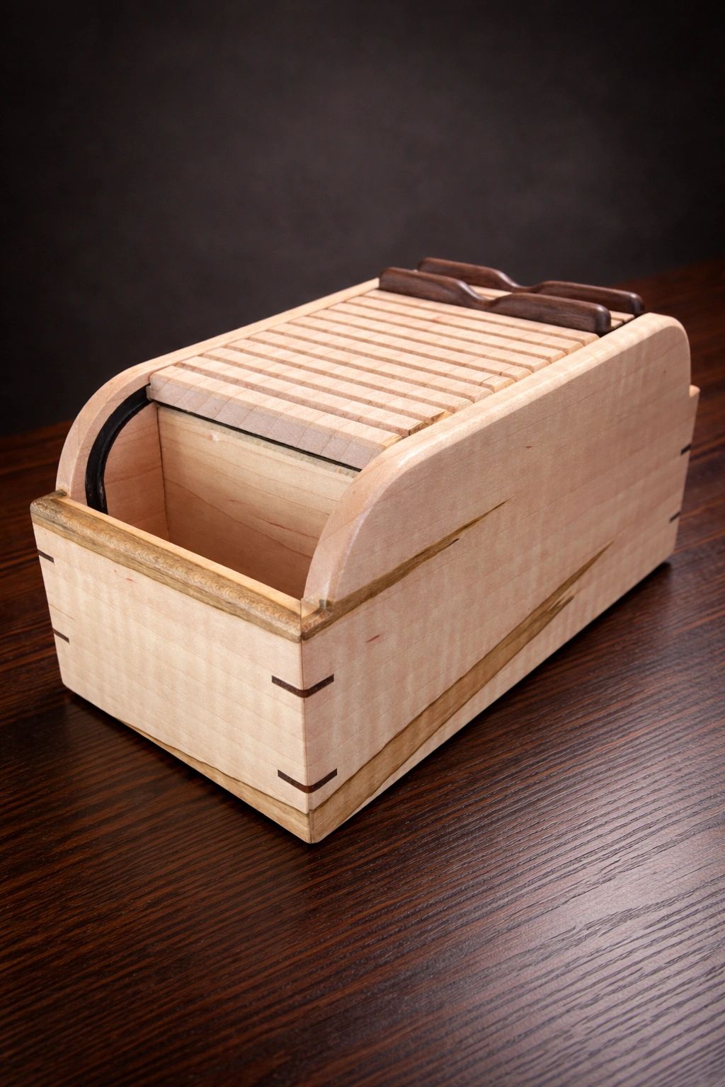 Handcrafted wooden box with sliding lid on a dark wood table.