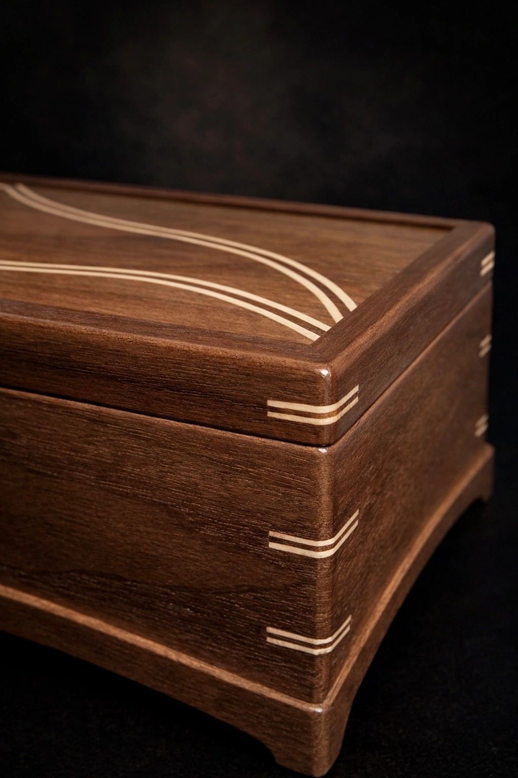Elegant wooden box with curved white inlay details.