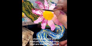 Hand painting a pink flower with a yellow center.