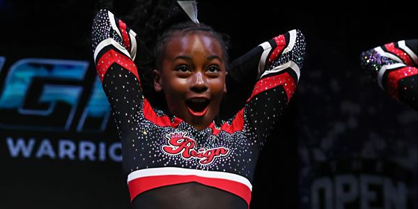 Excited cheerleader in red and black uniform.
