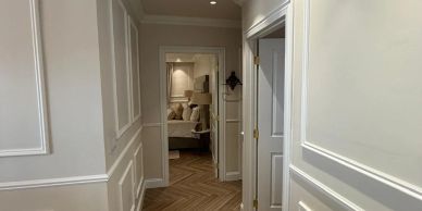 A hallway leading to a bedroom with modern wall paneling.