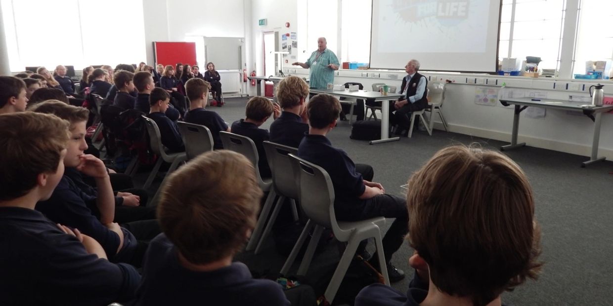 Students attentively listening to a speaker in a classroom setting.
