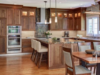 Modern kitchen with wooden cabinets, island, and dining area.