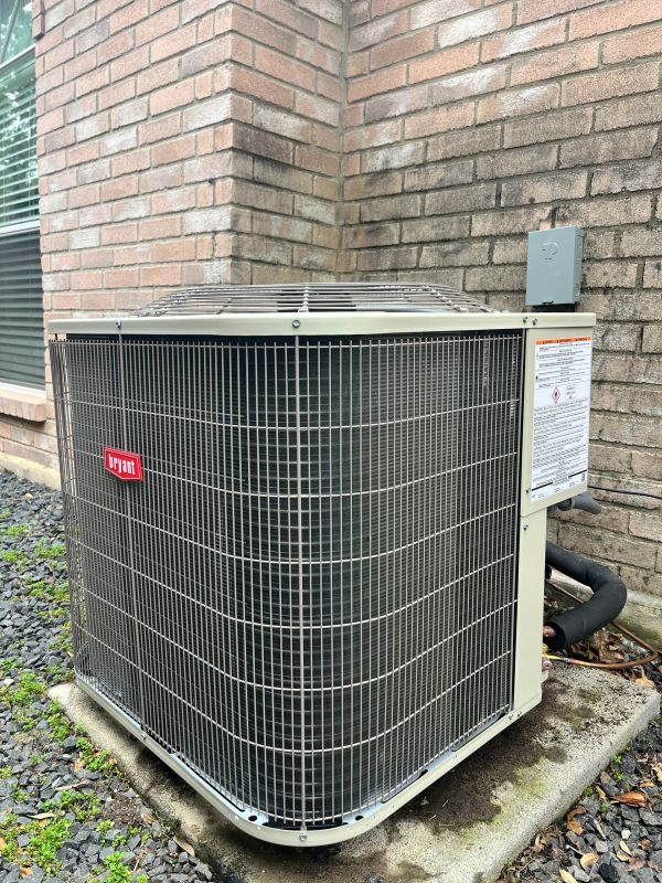 Outdoor Bryant air conditioning unit beside a brick wall.