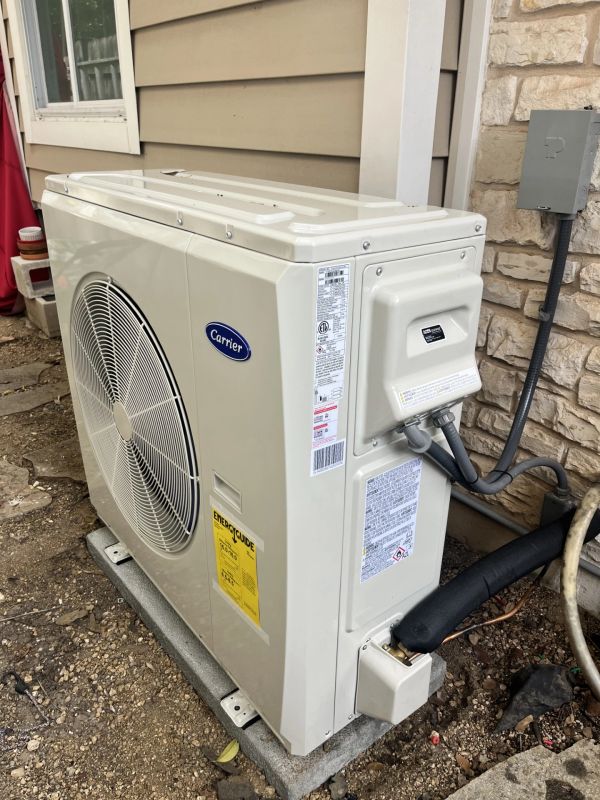 Outdoor Carrier air conditioning unit installed beside a house.