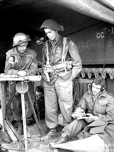 World War II soldiers operating communication equipment in a tent.