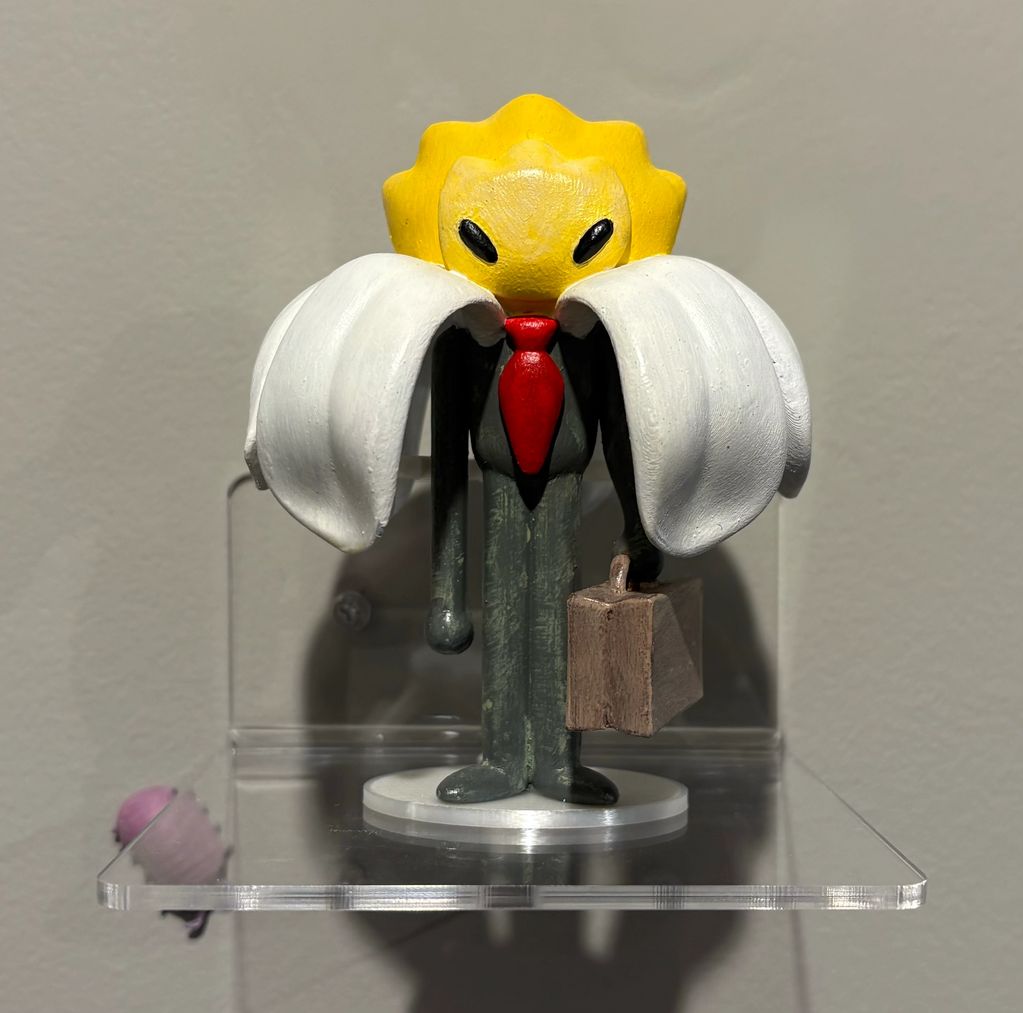 A figurine of a banana character with a red tie and briefcase.