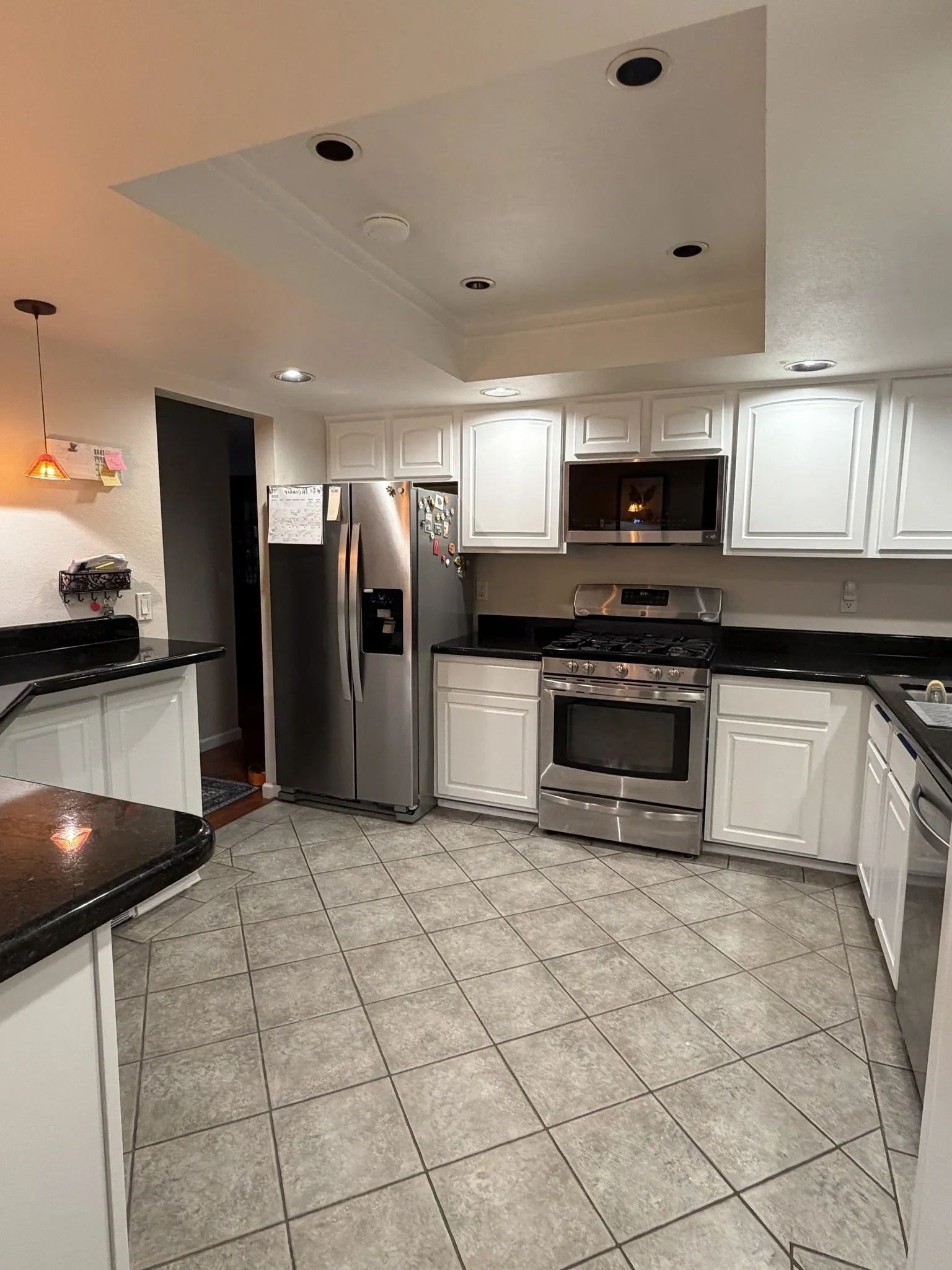 Modern kitchen with stainless steel appliances and white cabinets.